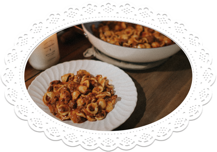 Homemade Hamburger Helper in a bowl, a glowing candle beside it.